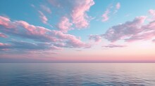 Pink-tinted Cirrus Clouds At Dusk Above A Serene Blue Ocean