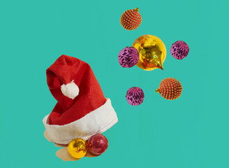 An isolated Santa Claus hat with Christmas baubles on a green background. Christmas pattern. Minimal concept. Copy space.