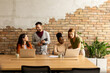 © BGStock72 - Young multiethnic startup team working by the brick wall in the industrial style office