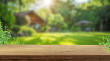 A Wood Table Space With Home Backyard, Blurred Background With House In Garden