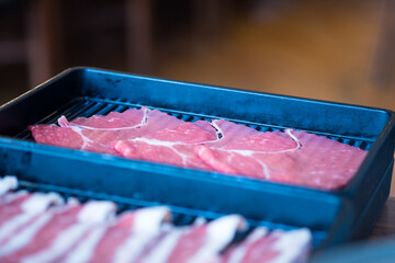 Wall Mural - Raw freshly thin beef for hot pot and Japanese sukiyaki served on long black tray