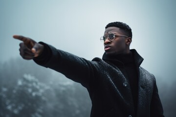 Poster - A man in a black coat pointing at something. Suitable for various business and communication concepts