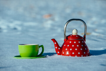 Wall Mural - Red teapot and green cup in the snow in winter