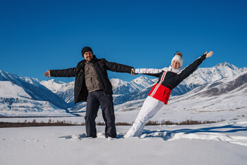 Sticker - Young happy couple of tourists on mountains background in winter