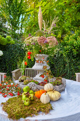 Beautiful autumnal table decoration, with many colorful flowers, in the garden.