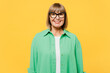 Elderly smiling happy cheerful fun satisfied blonde woman 50s years old wear green shirt glasses casual clothes looking camera isolated on plain yellow background studio portrait. Lifestyle concept.