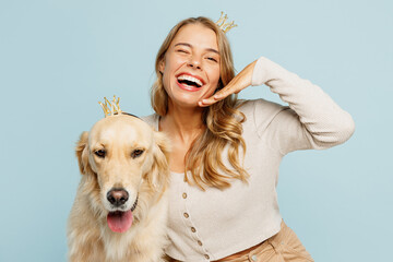 Wall Mural - Young cheerful happy owner woman wearing casual clothes crown diadem hug cuddle best friend retriever dog hold face isolated on plain pastel light blue background studio. Take care about pet concept.