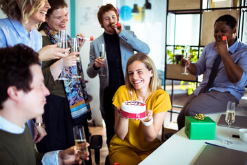 Wall Mural - Smiling young woman celebrating birthday in office