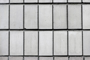 Poster - wall with gray tiles, closeup. Gray stone wall close up, photo texture, structure. old tiles, construction, repair. flat background for text. Masonry Stone Wall. Background Structure - Wallpaper