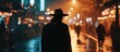 Man in hat and raincoat walking through city at night with striking silhouette.