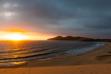 Canvas Print - sunrise view of the beach with mountain on the back.