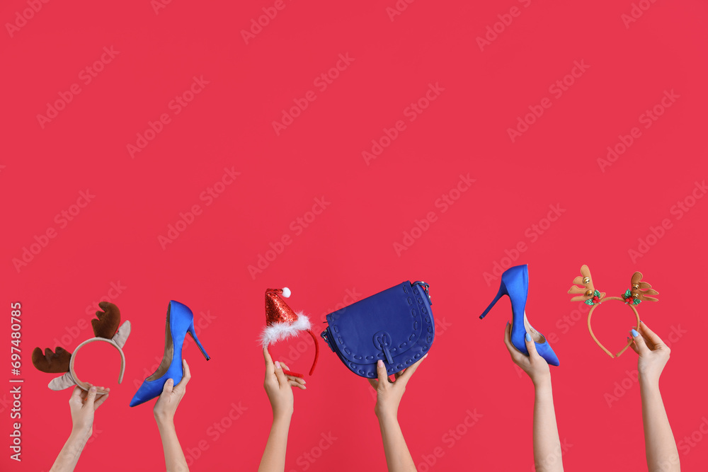 Many hands with Christmas headbands, shoes and bag on red background