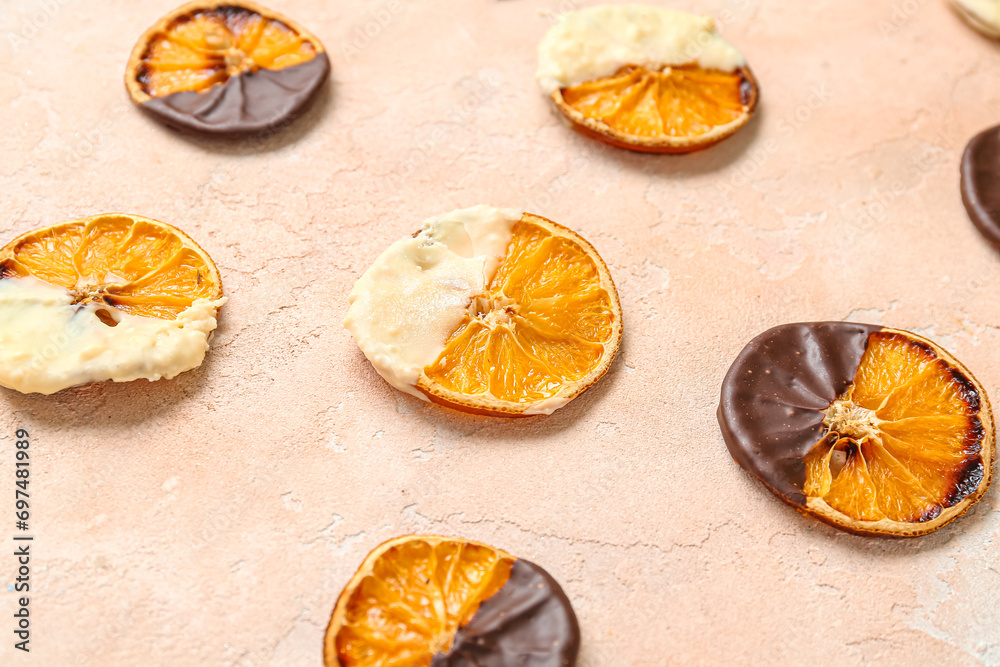 Chocolate dipped dried orange slices on beige background