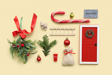 Wall Mural - Beautiful composition with door, ladder, Christmas tree, candy cane and decorations on yellow background