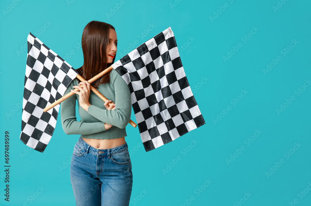 Beautiful young woman with racing flags on blue background
