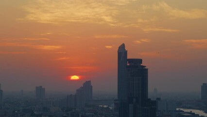 Wall Mural - Time lapse sunset over modern office buildings in business district. Skyline view of cityscape with disc sun sunlight and flare