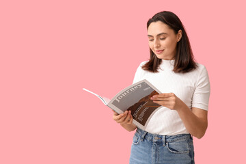 Wall Mural - Beautiful young woman reading journey magazine on pink background