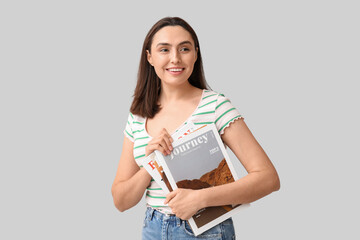 Wall Mural - Beautiful woman with magazines on light background