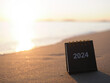 Close up 2024 desk calendar on the beach in the sunset time. Resolution, Goal, Action, Planning, and manage to success business.
