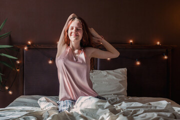 Wall Mural - Young woman waking up in bedroom, stretching arms