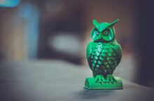 The Green Form In The Form Of A Small Owl Created On A 3d Printer Stands On The Surface Of A Dark Blurry Background Close-up. Progressive Modern Additive Technologies 4.0 Industrial Revolution