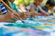 © SnapVault - A diverse group of multiracial children exploring their creativity in a painting activity at a summer camp in a natural setting.