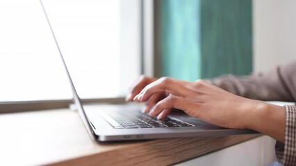 Close-up shot of a woman working on a laptop