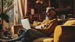 © EmmaStock - Mature handsome man stylish using a laptop in the living room with dog
