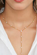 Young woman wearing a golden lariat necklace.