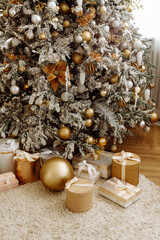 Wall Mural - Christmas gifts under the Christmas tree at home. Beige and gold shades.