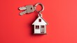  a house shaped keychain with a house shaped keychain hanging from it's side on a red background.