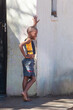 african child in a village, he is standing in front of the house daytime