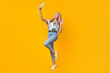Full size photo of adorable girl dressed print shirt jeans waving palm on smartphone doing selfie isolated on yellow color background