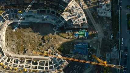 Wall Mural - Vertical top view of construction of circular building. Stock footage. Construction site of building near parking lot in city center. Construction of stadium in center of residential city on sunny