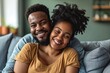 Black couple sitting on couch smiling