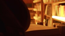 Close-up Of Mysterious Man Opening Large Book. Stock Footage. Man Opens Book In Dark Library With Flashing Light. Secret Society With Mysterious Books In Night Library