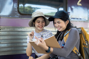 Two female friend talking about trip on their way to train. traveling concept