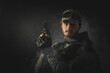 A man with the airsoft rifle in the smoke on the dark background. Special agent concept. Action movie film concept.