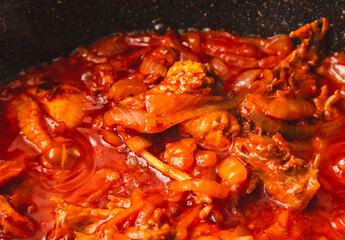 Poster - Chicken meat is stewed in tomato in a frying pan