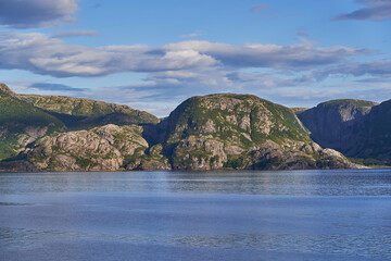 Landscape picture of wild and romantic coast of Norwegian sea in the North Norway during summer evening. Beautiful example of pure, clean and protected nature without people settlements and polutions.