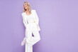 © halayalex - Portrait of young beautiful blond woman wearing nice trendy white suit. Fashion model posing in studio. Fashionable female isolated on violet background. Cheerful and happy