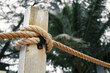 fence pole tied with rope, rope knot on fence of wooden bridge