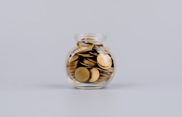 Saving money coins in a glass bottle Concepts of saving money, cash flow, assets and real estate. financial investment coin bank