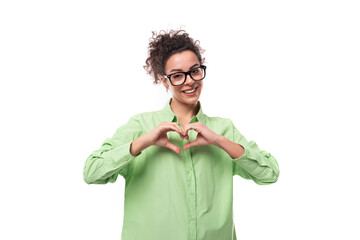 Wall Mural - young brunette businesswoman with curly hair dressed in a green shirt wears eyeglasses