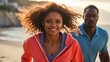 © Oleg Sevostyanov - African-American couple in brightly colored tracksuits, a girl and a man, athletes, walk against the ocean on a sunny day