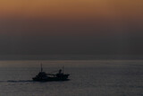 Fototapeta Kuchnia - 朝焼けの始まる頃の海をゆく船20231121