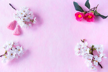 正月イメージ　桜の花と椿の花とタッセルのアレンジメント（ピンクバック）