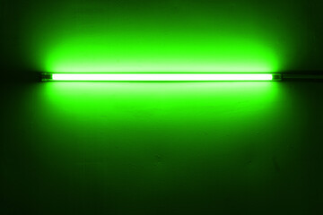 Green neon lamp on a white wall for design