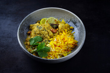 Wall Mural - Traditional spicy Indian chicken Madras curry with chicken breast, cashew nuts and saffron rice served as top view in a Nordic design plate with copy space