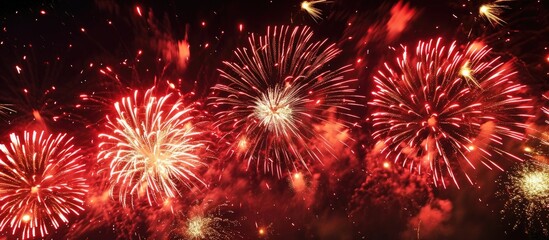 Fireworks display with red and golden bursts at night.